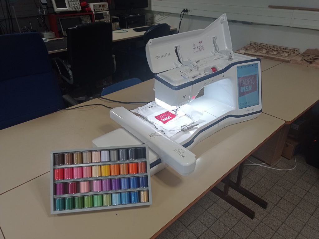 Brodeuse stellaire Innov-is XE1 du fablab accompagné d'un lot de fil à broder.